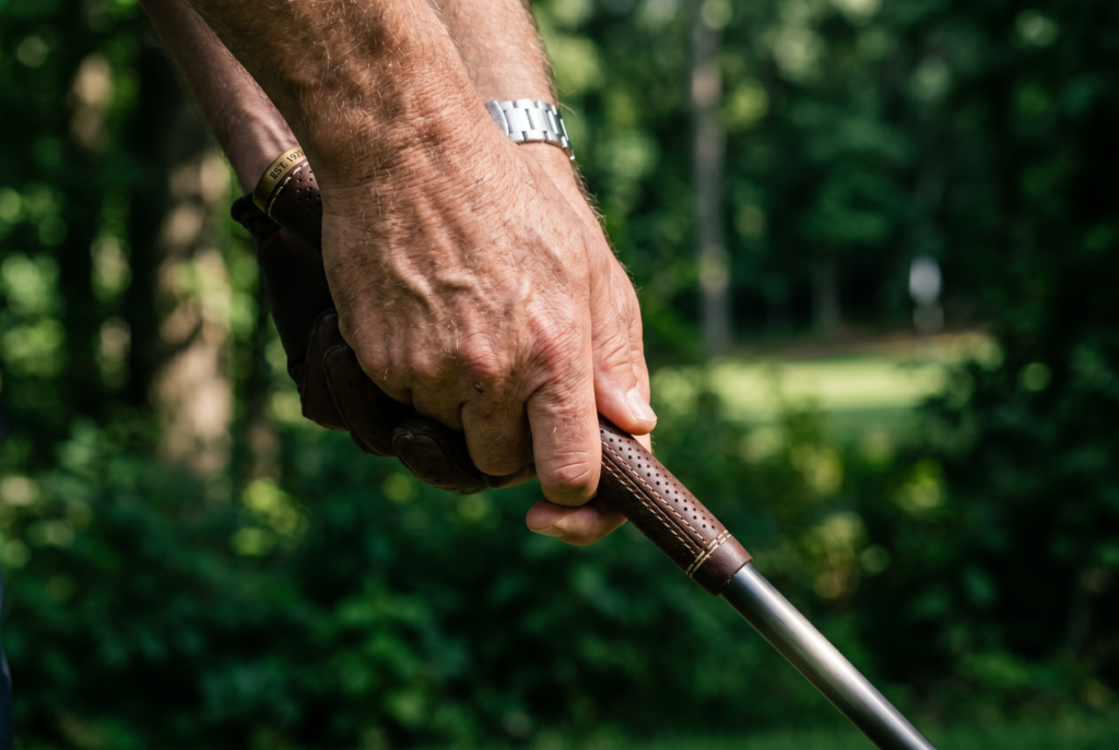 Close-up macro of a golfer gripping a club with visible leather texture.