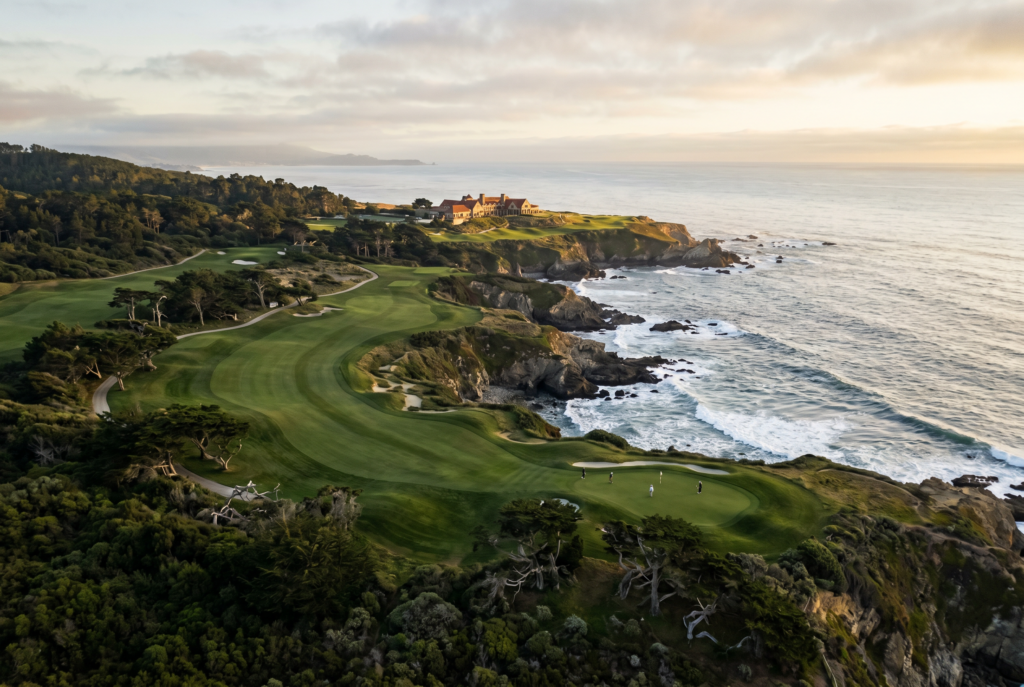 Aerial view of a coastal heritage golf course with fairways and sea horizon.